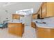 Bright kitchen with wood cabinetry, white countertops, and a large skylight at 3022 Forest Club Dr, Plant City, FL 33566