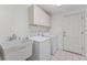 Functional laundry room with sink, washer, dryer, and upper cabinets at 3022 Forest Club Dr, Plant City, FL 33566