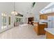 An open floor plan features a kitchen and living area with tile flooring, light fixtures, and large windows at 3022 Forest Club Dr, Plant City, FL 33566