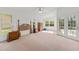 Spacious main bedroom featuring neutral carpet, ceiling fan, and natural light from outdoor views at 3022 Forest Club Dr, Plant City, FL 33566