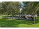 A well-maintained playground is shaded by mature trees and features a secure fence for safety at 3022 Forest Club Dr, Plant City, FL 33566