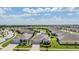 Beautiful aerial view of homes in a well-kept neighborhood with manicured lawns, sidewalks, and a pond at 31649 Tansy Bnd, Wesley Chapel, FL 33545