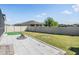 A spacious backyard with a stone patio, lush green lawn, and a wood fence for privacy at 31649 Tansy Bnd, Wesley Chapel, FL 33545