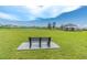 Enjoy picturesque views of a playground and the lake, from a resting bench on the lawn at 31649 Tansy Bnd, Wesley Chapel, FL 33545