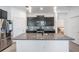 Modern kitchen with large island, stainless steel appliances, and sleek dark cabinets at 31649 Tansy Bnd, Wesley Chapel, FL 33545
