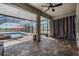 Screened lanai featuring an inground pool, brick pavers and sunshade with gray curtains at 31649 Tansy Bnd, Wesley Chapel, FL 33545