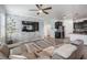 Modern living room with stylish stone accent wall, ceiling fan, and open access to the kitchen at 31649 Tansy Bnd, Wesley Chapel, FL 33545
