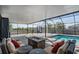 Screened pool featuring a gas firepit, brick pavers, and outdoor lounge furniture at 31649 Tansy Bnd, Wesley Chapel, FL 33545