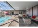 Relaxing screened-in pool area with comfortable seating and a stone fire pit for outdoor enjoyment at 31649 Tansy Bnd, Wesley Chapel, FL 33545