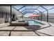Beautiful screened-in pool area with a swimming pool, hot tub, outdoor kitchen, and covered patio at 31649 Tansy Bnd, Wesley Chapel, FL 33545