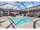Lovely screened-in pool area with a large swimming pool, hot tub, and an outdoor kitchen at 31649 Tansy Bnd, Wesley Chapel, FL 33545