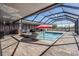 Beautiful screened-in pool area with a swimming pool, hot tub, outdoor kitchen, and covered patio at 31649 Tansy Bnd, Wesley Chapel, FL 33545