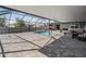 An enclosed pool and outdoor living space featuring a brick patio, a built in fire place, and comfortable seating at 31649 Tansy Bnd, Wesley Chapel, FL 33545