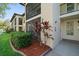 The building's exterior features a beige stucco, a screened porch, and neatly arranged landscaping at 3380 Crystal Court E # G, Palm Harbor, FL 34685