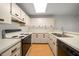 Bright kitchen features white cabinets, laminate countertops, an oven, and wood-look flooring at 3380 Crystal Court E # G, Palm Harbor, FL 34685