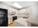 Cozy kitchen features a black refrigerator, a white oven, and white cabinets with laminate countertops at 3380 Crystal Court E # G, Palm Harbor, FL 34685