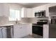 Stylish kitchen with stainless steel appliances, white cabinets, and plenty of natural light from a window at 5143 Jasmine Cir, St Petersburg, FL 33714