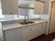 This kitchen offers white cabinets, sleek countertops, and a stainless steel sink at 5904 Willow Ridge Dr # 202, Zephyrhills, FL 33541