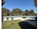 Outdoor pool surrounded by green grass, palm trees and various seating and lounge chairs at 5904 Willow Ridge Dr # 202, Zephyrhills, FL 33541