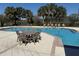 Outdoor pool features a patio seating area with tables and chairs by the clear blue water at 5904 Willow Ridge Dr # 202, Zephyrhills, FL 33541