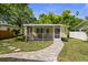 The backyard has a screened-in patio and beautiful walkway at 617 Scotland St, Dunedin, FL 34698