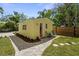 Detached structure with paver walkway and patio seating area with green grass and landscaping at 617 Scotland St, Dunedin, FL 34698