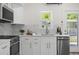 Bright kitchen with white cabinets, stainless steel appliances, and marble countertops at 617 Scotland St, Dunedin, FL 34698