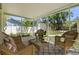 Inviting sunroom features wicker furniture, patterned rug, and a view of the backyard at 617 Scotland St, Dunedin, FL 34698