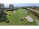 Scenic aerial view of a lush golf course with sand traps, water feature, and golfers enjoying a sunny day at 6269 Palma Del Mar S Blvd # 112, St Petersburg, FL 33715