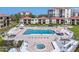 A large pool is surrounded by lounge chairs, palm trees, manicured lawns, and residential units at 6269 Palma Del Mar S Blvd # 112, St Petersburg, FL 33715