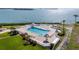 Aerial view of a pool and lounge chairs with an ocean view on a bright, sunny day at 6269 Palma Del Mar S Blvd # 112, St Petersburg, FL 33715