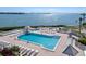 A beautiful pool with an ocean view is surrounded by lounge chairs and well-manicured landscaping at 6269 Palma Del Mar S Blvd # 112, St Petersburg, FL 33715