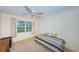 View of a bedroom with a ceiling fan and large windows that look out onto the lawn at 650 Pinellas Point S Dr # 216, St Petersburg, FL 33705