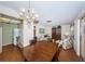 Open dining and living area with chandelier, wood floors, and a view into the kitchen with white appliances at 650 Pinellas Point S Dr # 216, St Petersburg, FL 33705