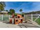 Outdoor barbeque area with brick grills and preparation space, surrounded by a white fence at 650 Pinellas Point S Dr # 216, St Petersburg, FL 33705