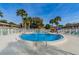 Community pool area featuring palm trees and lounge chairs near residential buildings at 650 Pinellas Point S Dr # 216, St Petersburg, FL 33705