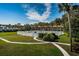 Outdoor pool and surrounding landscape featuring palm trees and sunny skies at 650 Pinellas Point S Dr # 216, St Petersburg, FL 33705