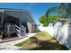 Backyard featuring shed, white fence and stairs to small porch at 6505 Bimini Ct, Apollo Beach, FL 33572