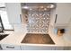 Updated kitchen featuring mosaic backsplash, stainless vent hood, electric cooktop and quartz countertops at 6505 Bimini Ct, Apollo Beach, FL 33572