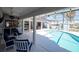 Enjoy poolside relaxation in a screened lanai with a wet bar and comfortable seating area at 6505 Bimini Ct, Apollo Beach, FL 33572