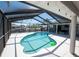 Enclosed pool with white tile and a green ball floating in the water, surrounded by a screened enclosure at 6505 Bimini Ct, Apollo Beach, FL 33572