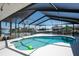 Beautiful kidney-shaped pool with turquoise water, surrounded by a screened enclosure and waterfront views at 6505 Bimini Ct, Apollo Beach, FL 33572