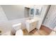 Updated bathroom features a vanity with modern fixtures, tile accents, and wood-look flooring at 7014 Westcott Dr, Port Richey, FL 34668