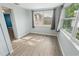 Bright bedroom featuring light-colored walls, wood floors, and natural light with backyard views at 7014 Westcott Dr, Port Richey, FL 34668