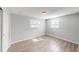 Bright bedroom with wood-look floors, ample natural light from two windows, and a closet at 7014 Westcott Dr, Port Richey, FL 34668