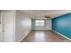Bright living area features laminate flooring, a ceiling fan, and natural light from a window at 7014 Westcott Dr, Port Richey, FL 34668
