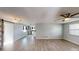Bright living room with wood-look floors and open floor plan has a view into the kitchen at 7014 Westcott Dr, Port Richey, FL 34668