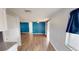 Inviting living space showcases wood-look floors, fresh blue paint, and a barn door to the bedroom at 7014 Westcott Dr, Port Richey, FL 34668