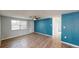 Spacious living area featuring hardwood floors, blue accent wall, and natural light at 7014 Westcott Dr, Port Richey, FL 34668