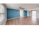Spacious living space with blue accent wall, hardwood floors, and sliding door at 7014 Westcott Dr, Port Richey, FL 34668